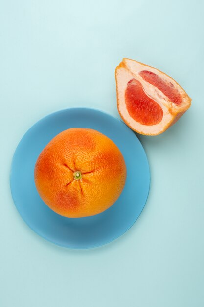 Verse grapefruit binnen blauwe plaat op een lichte vloer