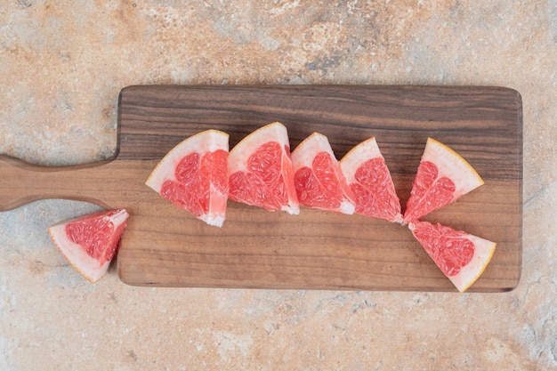 Verse grapefruitplakken op een houten bord.