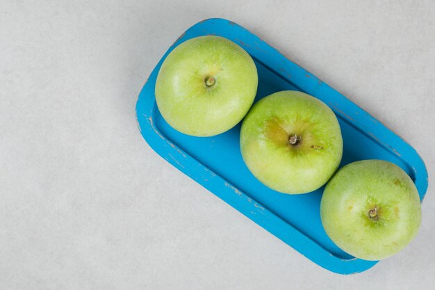 Verse groene appels op blauw bord