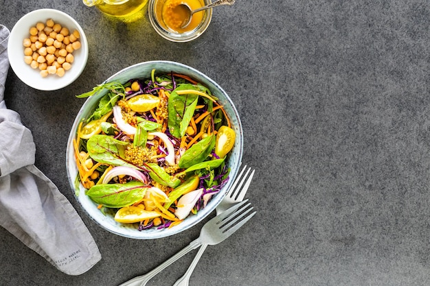 Verse groente- en fruitsalade in een bord op een zwarte stenen achtergrond bovenaanzicht