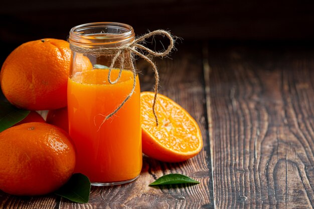 Verse jus d'orange in het glas op donkere houten achtergrond