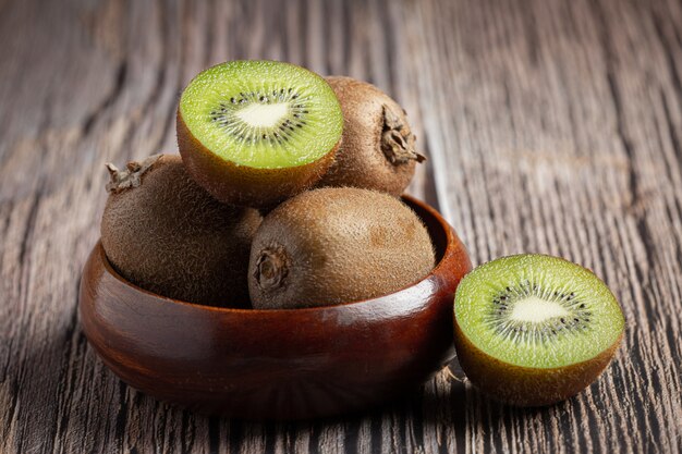 Verse kiwi, in tweeën gesneden, op een houten kom gelegd