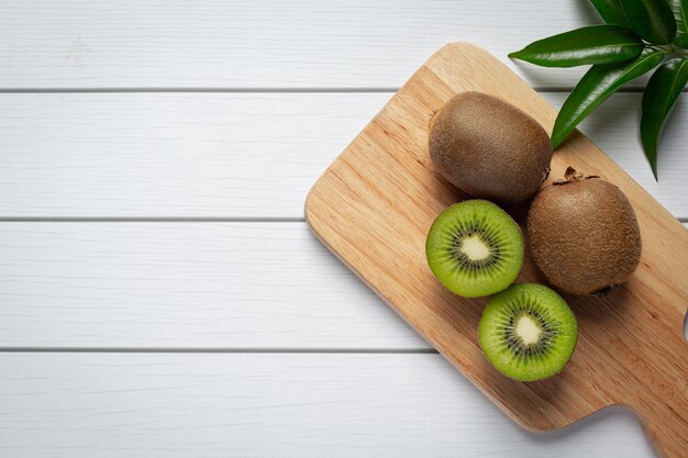 Verse kiwi, in tweeën gesneden, op een houten snijplank gelegd