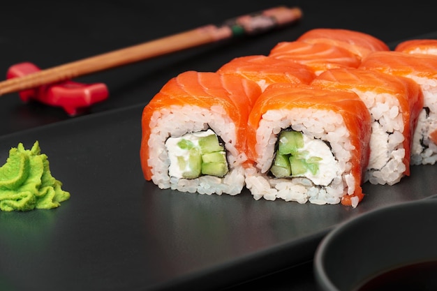 Verse philadelphia sushi roll geserveerd op zwarte plaat