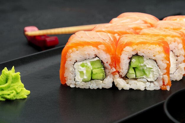 Verse philadelphia sushi roll geserveerd op zwarte plaat