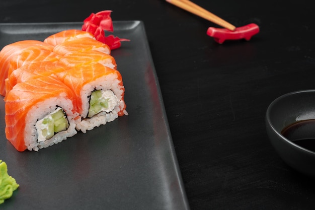 Verse philadelphia sushi roll geserveerd op zwarte plaat