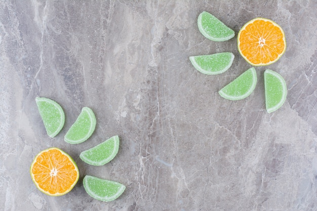 Gratis foto verse plakjes sinaasappel met zoete marmelade op marmeren achtergrond.