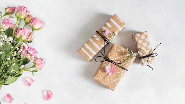 Verse prachtige rozen in de buurt van geschenkdozen en bloemblaadjes