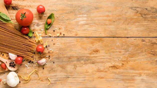 Verse rauwe Italiaanse ingrediënten met spaghetti pasta over geweven tafel