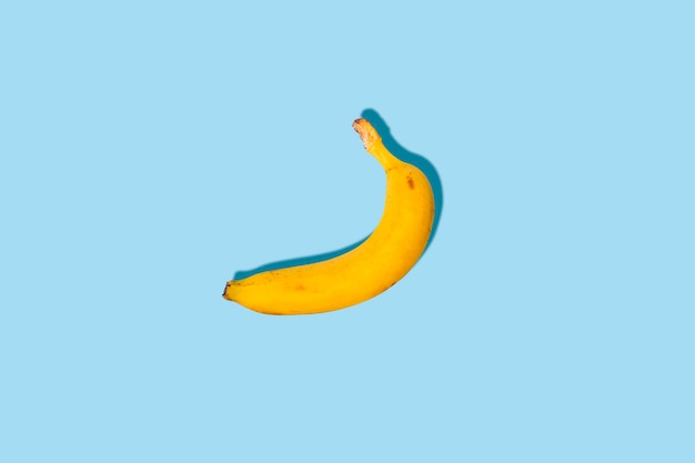 Verse rijpe banaan op een blauwe achtergrond. bovenaanzicht, plat gelegd. Premium Foto