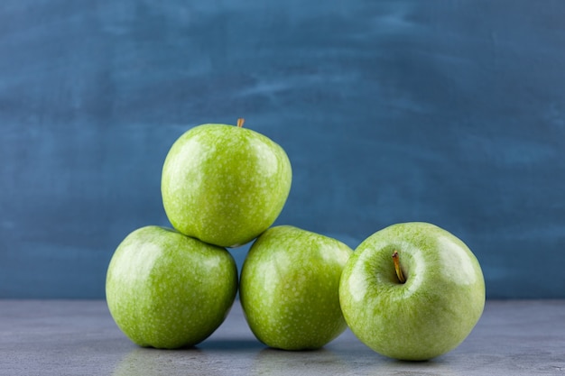 Verse rijpe groene appels geplaatst op een stenen oppervlak.