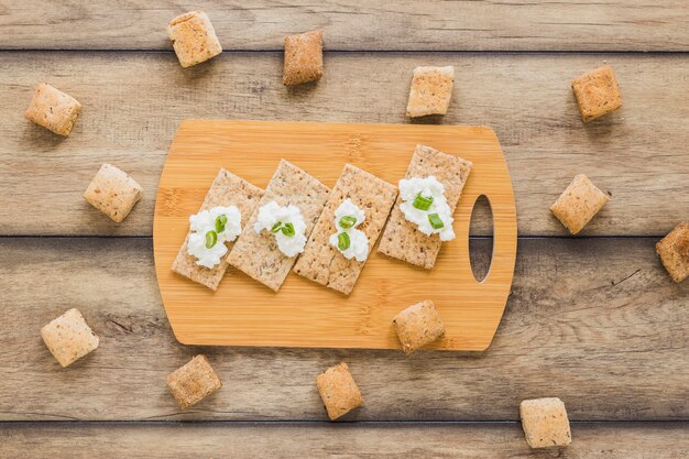 Verse roomkaas op kernachtig brood over het hakbord op bureau