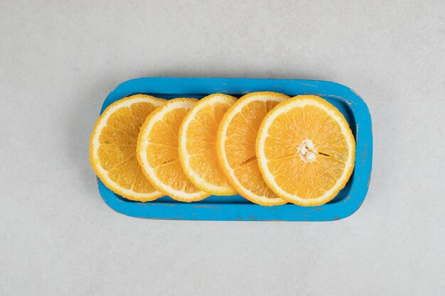 Verse sinaasappelschijfjes op blauw bord