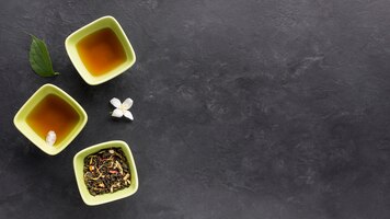 Verse thee met gedroogde kruiden en jasmijnbloem op zwarte ondergrond