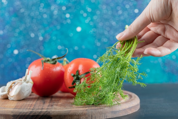 Verse tomaten met knoflook op een houten bord.