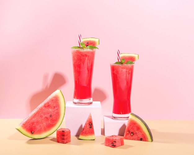 Verse watermeloensap en watermeloenschijf op pastelkleurige achtergrond koelende drank zomerdrank
