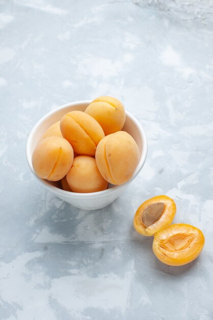 verse zoete abrikozen zacht en lekker fruit in plaat op wit bureau, fruit vers zomer eten maaltijd vitamine
