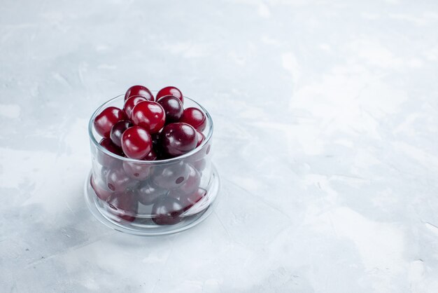 verse zure kersen in kleine glazen beker op wit-licht bureau, fruit zure vitamine foto