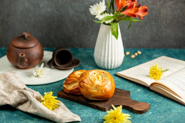 Versgebakken broodjes, open boek en bloemen