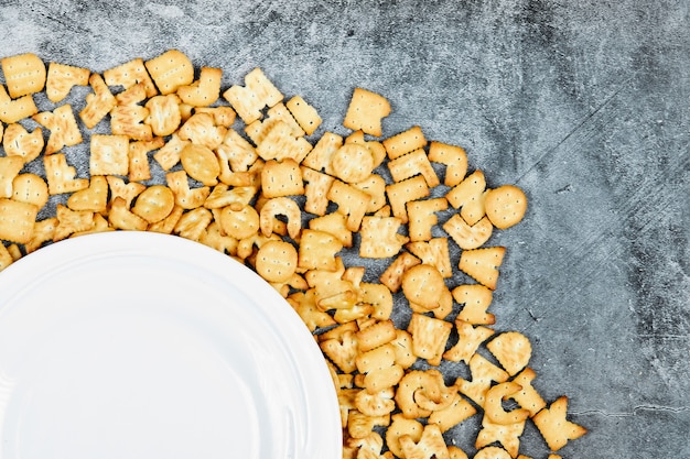 Verspreide alfabetcrackers rond een leeg bord.