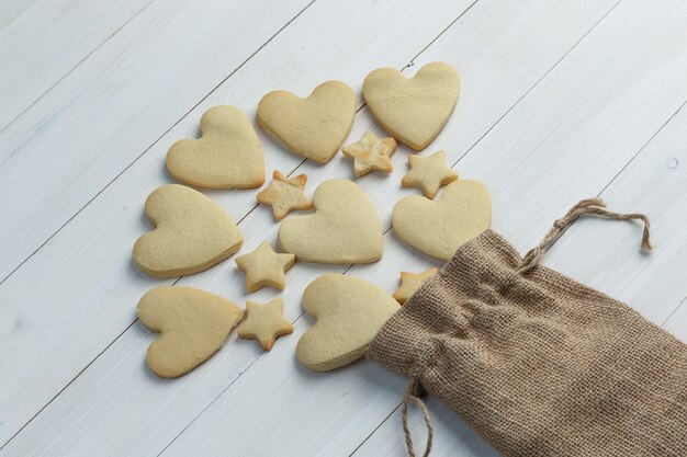 Verspreide koekjes uit een zak op een houten achtergrond. hoge kijkhoek.