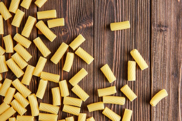 Verspreide tortiglioni pasta plat lag op een houten tafel