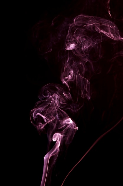 Gratis foto verspreiding van roze rook op de zwarte achtergrond