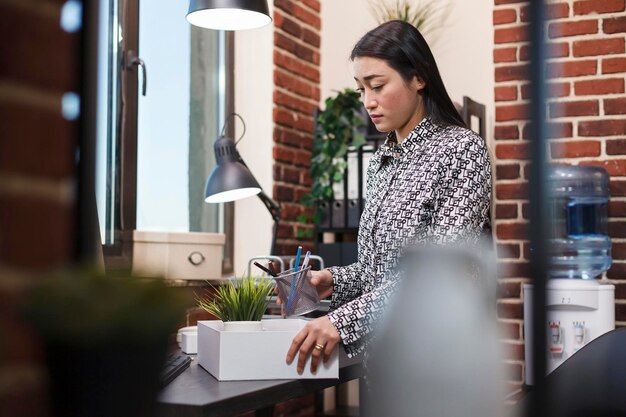 Verstoorde kantoormedewerker van het bedrijf die persoonlijke voorwerpen verzamelt nadat hij is ontslagen door de organisatieleider. Bedrijfsmedewerker stopt haar spullen in een kartonnen doos nadat ze ontslagen is.