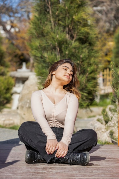 Verticaal portret van een jong mooi meisje dat haar benen kruiste en op de grond zat Foto van hoge kwaliteit