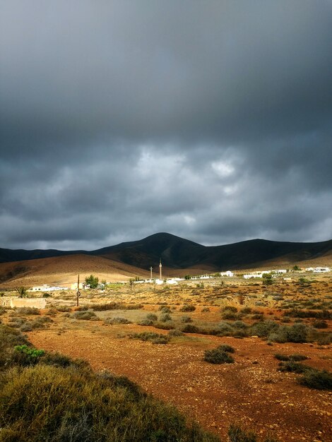 Verticaal schot van droge vallei en heuvels in schaduwen vóór het stormachtige weer in Fuerteventura, Spanje