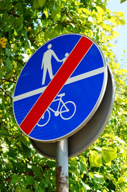 Gratis foto verticaal schot van een blauw bord dat de toegang van mensen en fietsen verbiedt