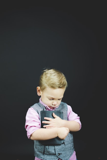Verticaal schot van een kind dat de bijbel tegen zijn borst houdt