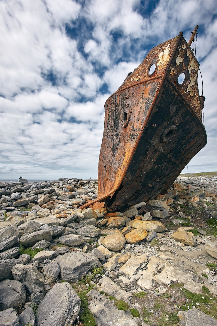 Gratis Foto verticaal schot van een roestig karkas van het plassy-schip in aran-eilanden, ierland