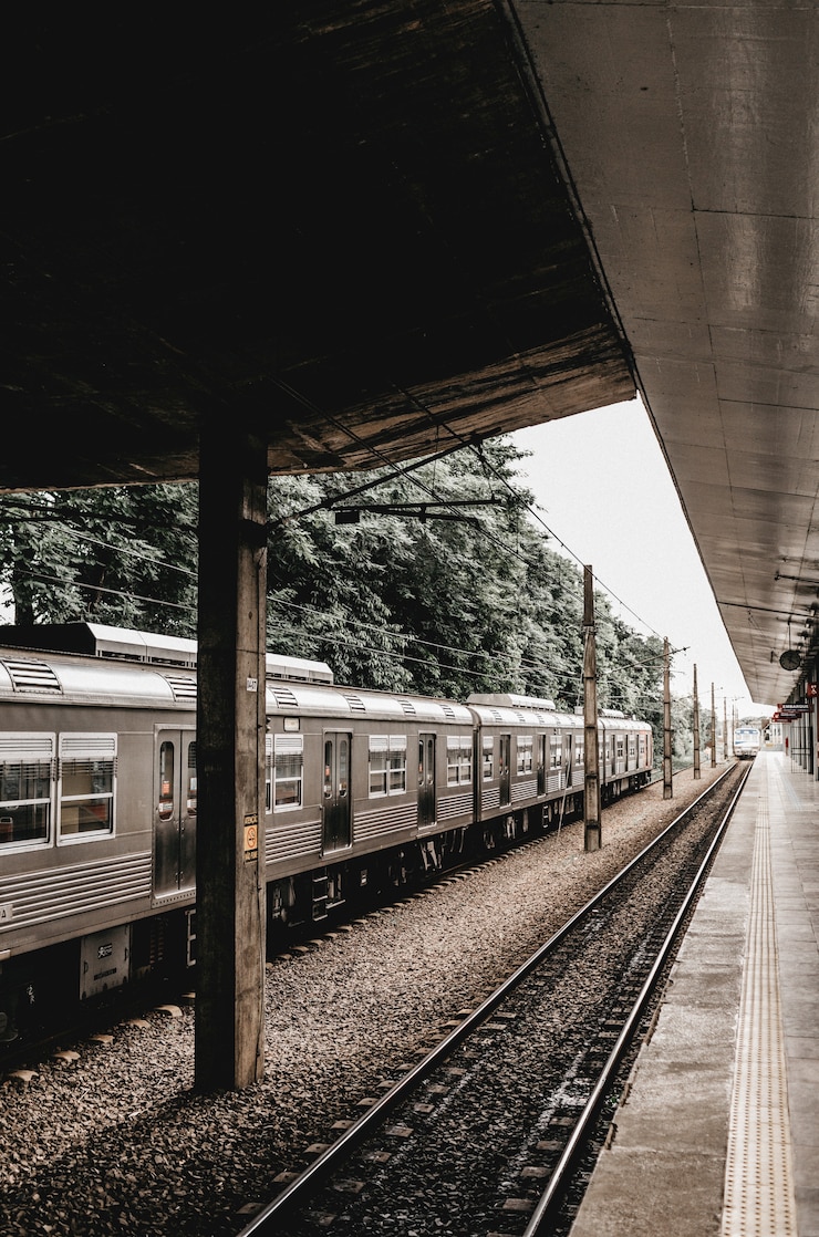 Gratis Foto verticaal schot van een treinstop met het grijze metaaltrein weggaan