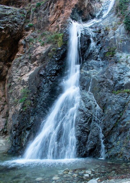 Verticaal schot van een waterval die langs de rotsen komt