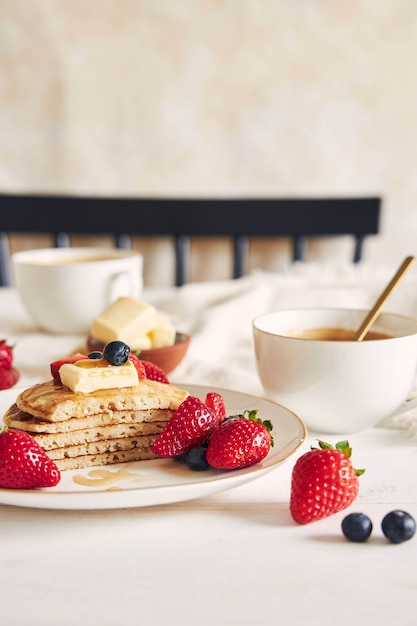 Verticaal schot van gesneden veganistische pannenkoeken met fruit en stroop