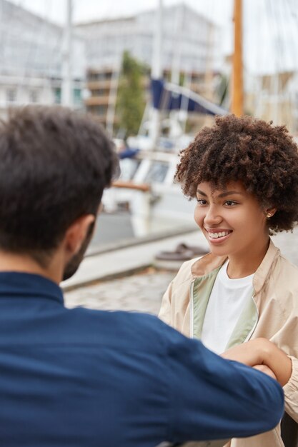 Verticaal schot van glimlachend donkerhuidig meisje heeft Afro-kapsel, brede glimlach
