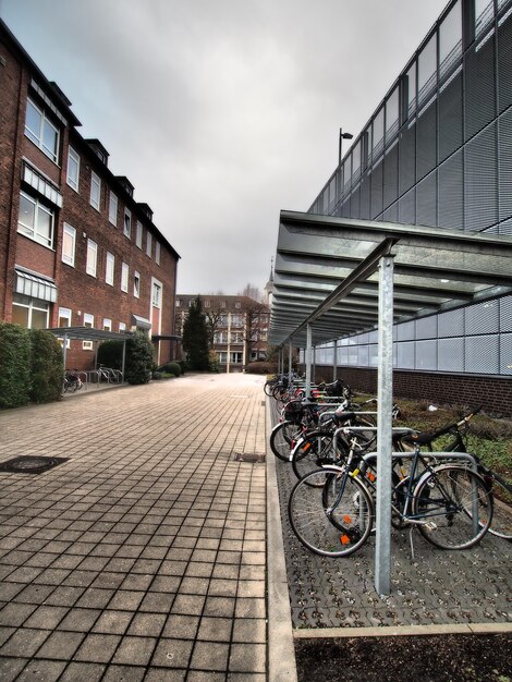 Verticaal schot van meerdere fietsen die naast een gebouw geparkeerd staan