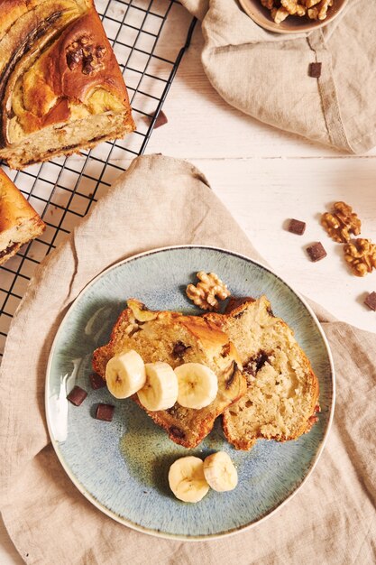 Verticaal schot van plakjes heerlijk bananenbrood met chocoladestukjes en walnoot op een bord