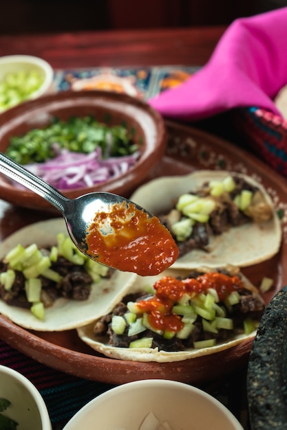 Verticaal schot van tortilla's met vlees gezien door tomatensauslepel