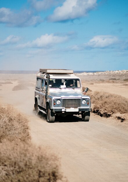 Verticaal van een off-road auto die zich in een woestijnweg beweegt