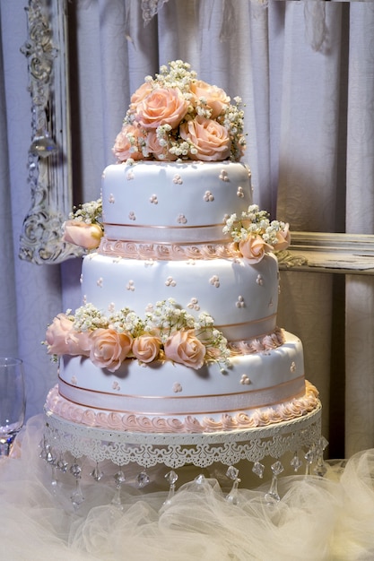 Verticale close-up shot van een mooie drielaagse cake met roze decoraties