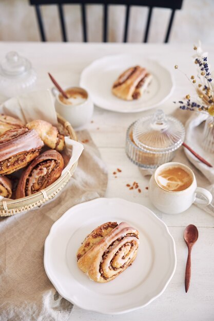 Verticale close-up shot van heerlijke notenslakken met koffie Cappuccino op de witte houten tafel