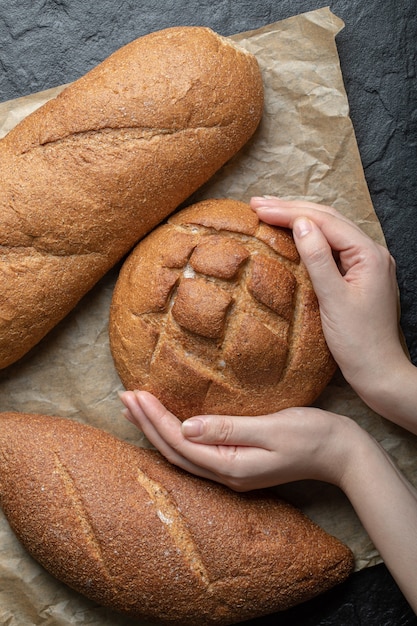 Verticale foto van de roggebrood van de vrouwenholding.