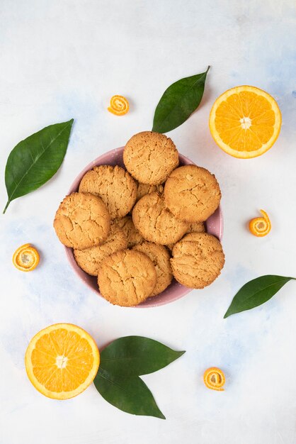 Verticale foto van zelfgemaakte koekjes in roze kom over witte tafel.