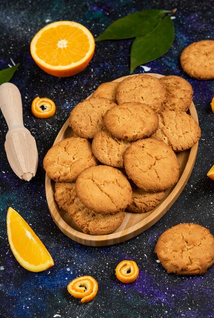Verticale foto van zelfgemaakte verse koekjes en koekje met sinaasappel over ruimteoppervlak.