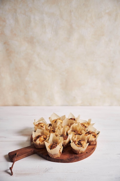 Verticale hoge hoek shot van heerlijke chocolademuffin op een houten plaat op een witte tafel