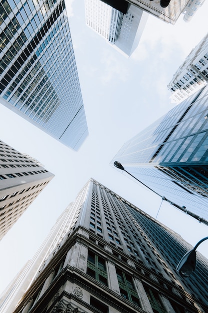 Gratis foto verticale lage hoek shot van de wolkenkrabbers onder de heldere hemel in new york city, verenigde staten