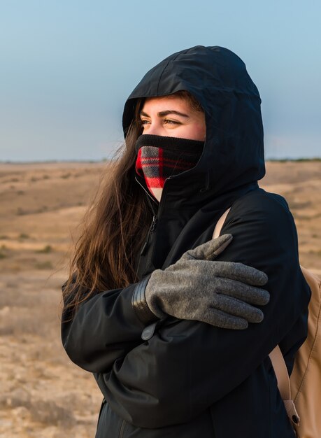Verticale ondiepe focus close-up van een vrouw die zichzelf knuffelt vanwege koud weer