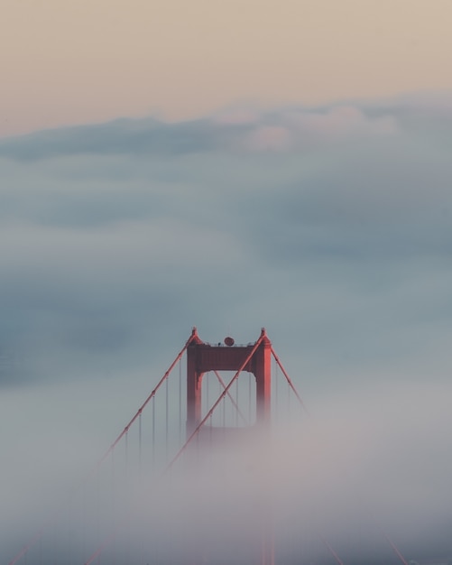 Gratis foto verticale opname van de golden gate bridge, omringd door wolken